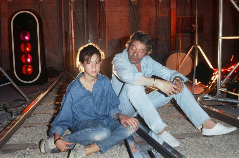 Serge, chaussé de Zizi, et Charlotte Gainsbourg en 1986. - AFP