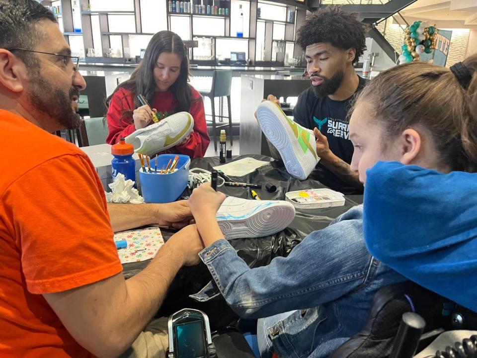 Charlotte Hornets center Nick Richards paints a shoe with children facing life-threatening conditions at the “Hornets Hoopin’ Holidays” event Thursday at Spectrum Center.