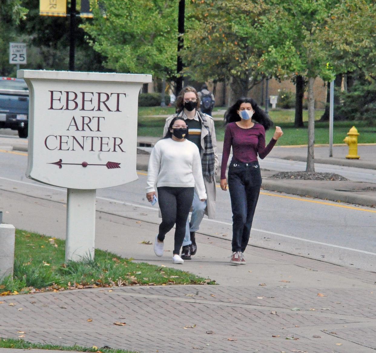 College of Wooster students wear face masks as they cross the campus. The college renewed its face mask policy this week after recent outbreaks of COVID-19.