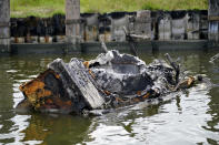 Part of a shrimp boat, one of several that caught fire and burned during Hurricane Ida, lies in the channel of Delta Marina in Plaquemines Parish, La., Monday, Sept. 13, 2021. The wrecked boats, docks and processing equipment left by Hurricane Ida has some wondering what the future holds for Louisiana's seafood industry. (AP Photo/Gerald Herbert)