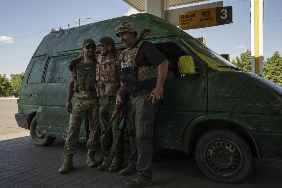 FILE Ukrainian soldiers pose for a photograph as they fill up the tank of their van at a gas station, in Konstantinovka, Donetsk Oblast, eastern Ukraine, Friday, July 15, 2022. Ukrainians living in the path of Russia's invasion in the besieged eastern Donetsk region are bracing themselves for the possibility that they will have to evacuate. (AP Photo/Nariman El-Mofty, File)