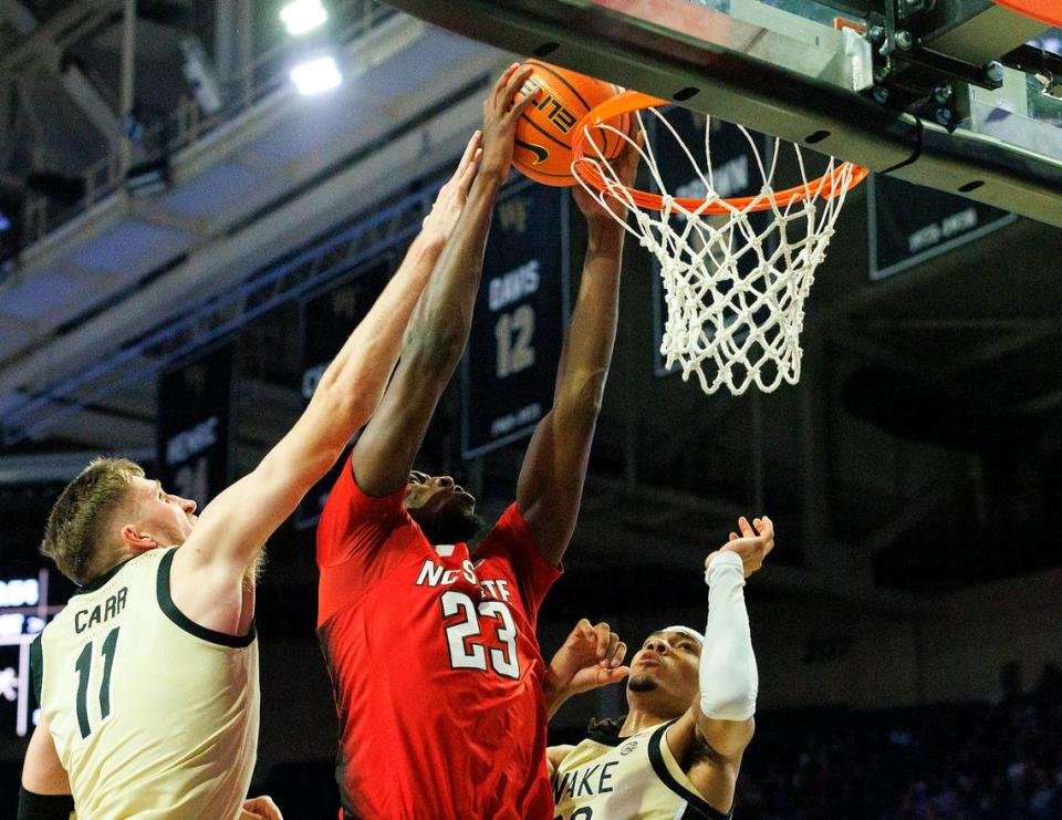 N.C. State’s Mohamed Diarra dunks over Wake Forest’s Andrew Carr and Hunter Sallis during the first half of the Wolfpack’s game on Saturday, Feb. 10, 2024, at Lawrence Joel Veterans Memorial Coliseum in Winston-Salem, N.C. Kaitlin McKeown/kmckeown@newsobserver.com