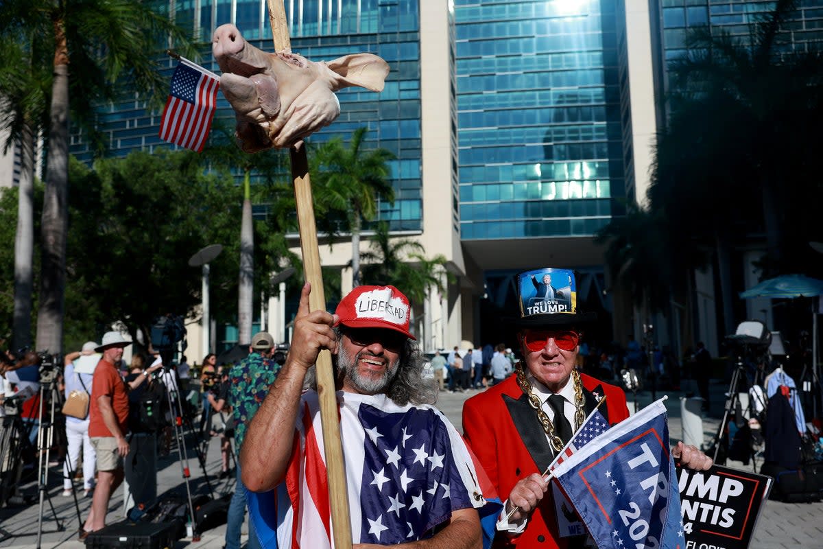 Osmany Estrada (L) holds a pigs head as he and Gregg Donovan gather outside the Wilkie D. Ferguson Jr. United States Federal Courthouse (Getty Images)