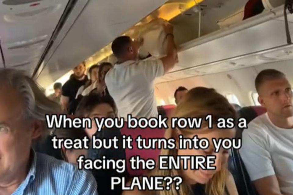 Jess Smith booked the first row as a ‘treat’ but realised she was in for an awkward plane journey after facing towards all other passengers (@jesssmith_36/TikTok)