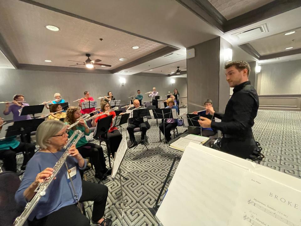 Zachery Meier conducts the Iowa City Flute Choir.