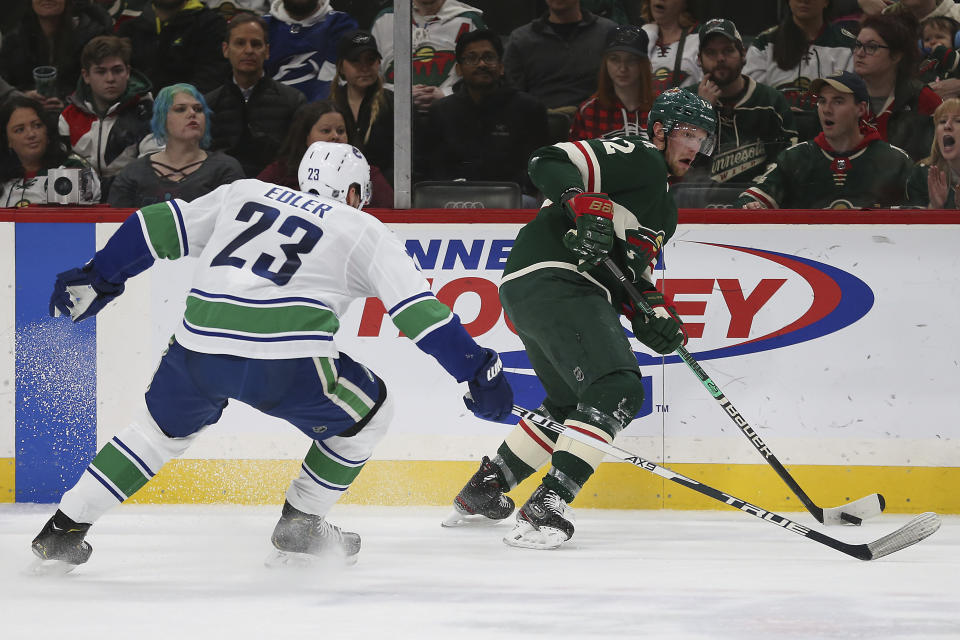 Minnesota Wild's Eric Staal, right, controls the puck against Vancouver Canucks' Alexander Edler, of Sweden, in the second period of an NHL hockey game Sunday, Jan. 12, 2020, in St. Paul, Minn. (AP Photo/Stacy Bengs)