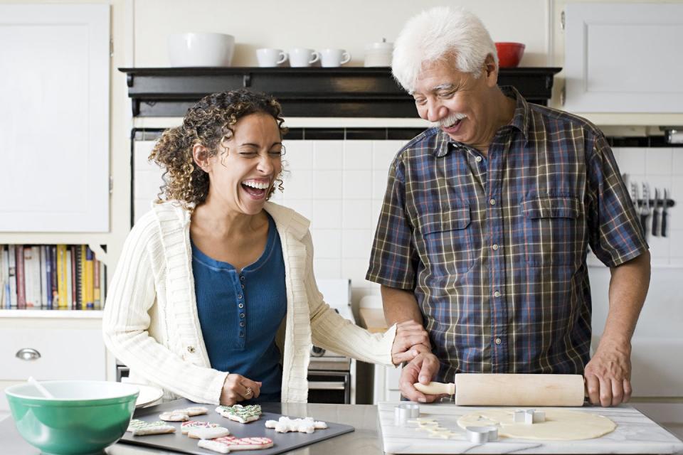 a father and daughter laughing while making cookies