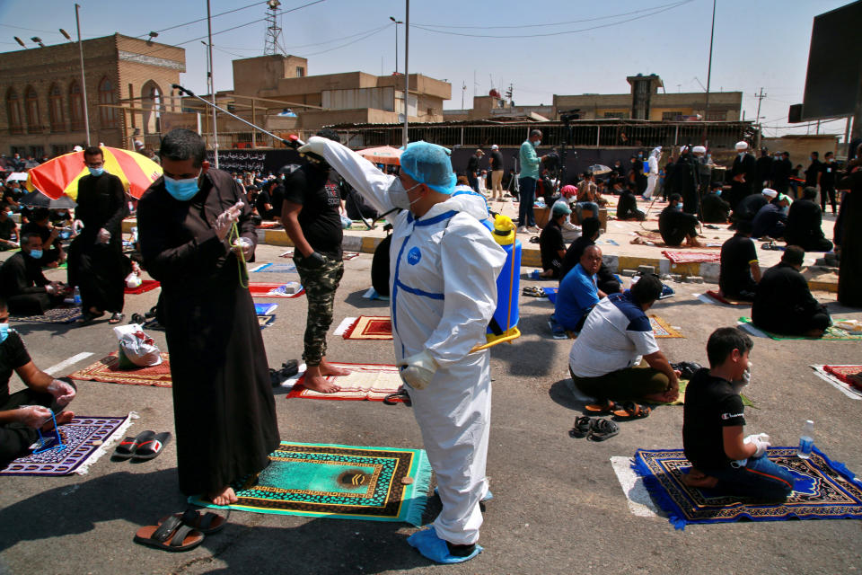 File - In this Friday, Sept. 11, 2020 file photo, a volunteer sprays disinfectant as a precaution against the coronavirus, during the open-air Friday prayers in Sadr City, Baghdad, Iraq. (AP Photo/Khalid Mohammed, File)