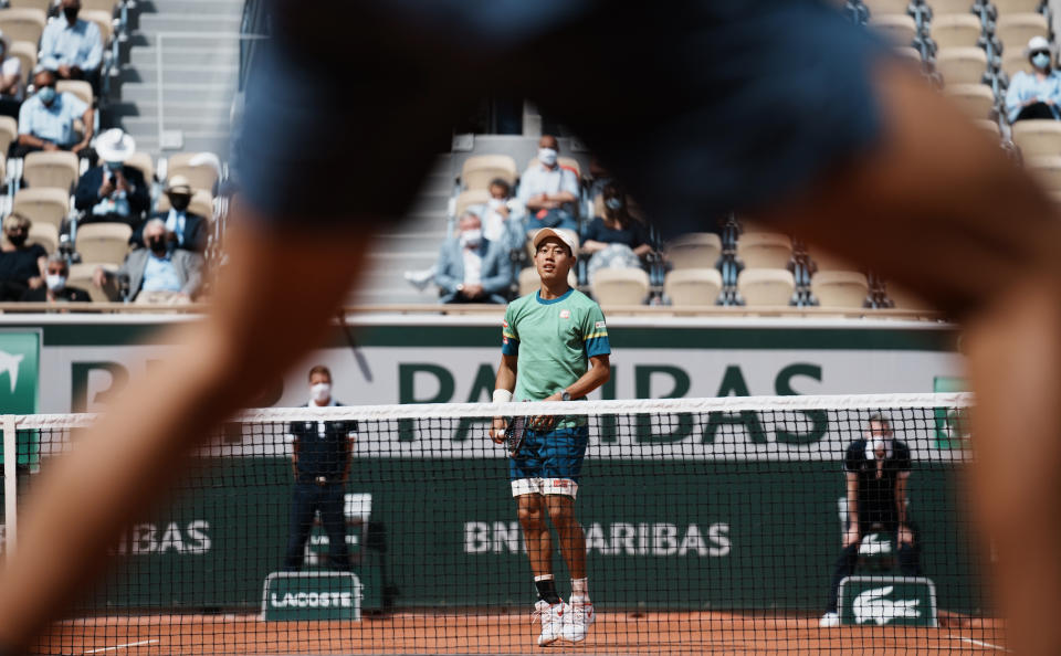 Japan's Kei Nishikori jumps to see where the ball lands as he plays against Russia's Karen Khachanov during their second round match on day four of the French Open tennis tournament at Roland Garros in Paris, France, Wednesday, June 2, 2021. (AP Photo/Thibault Camus)