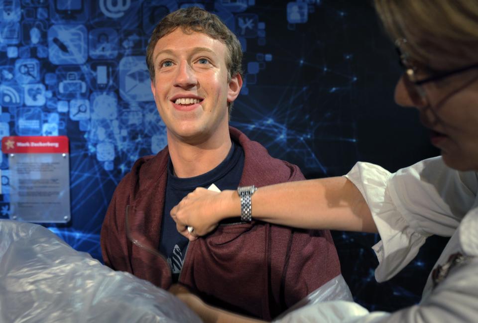 Mark Zuckerberg smiling whilst wearing a maroon sweatshirt