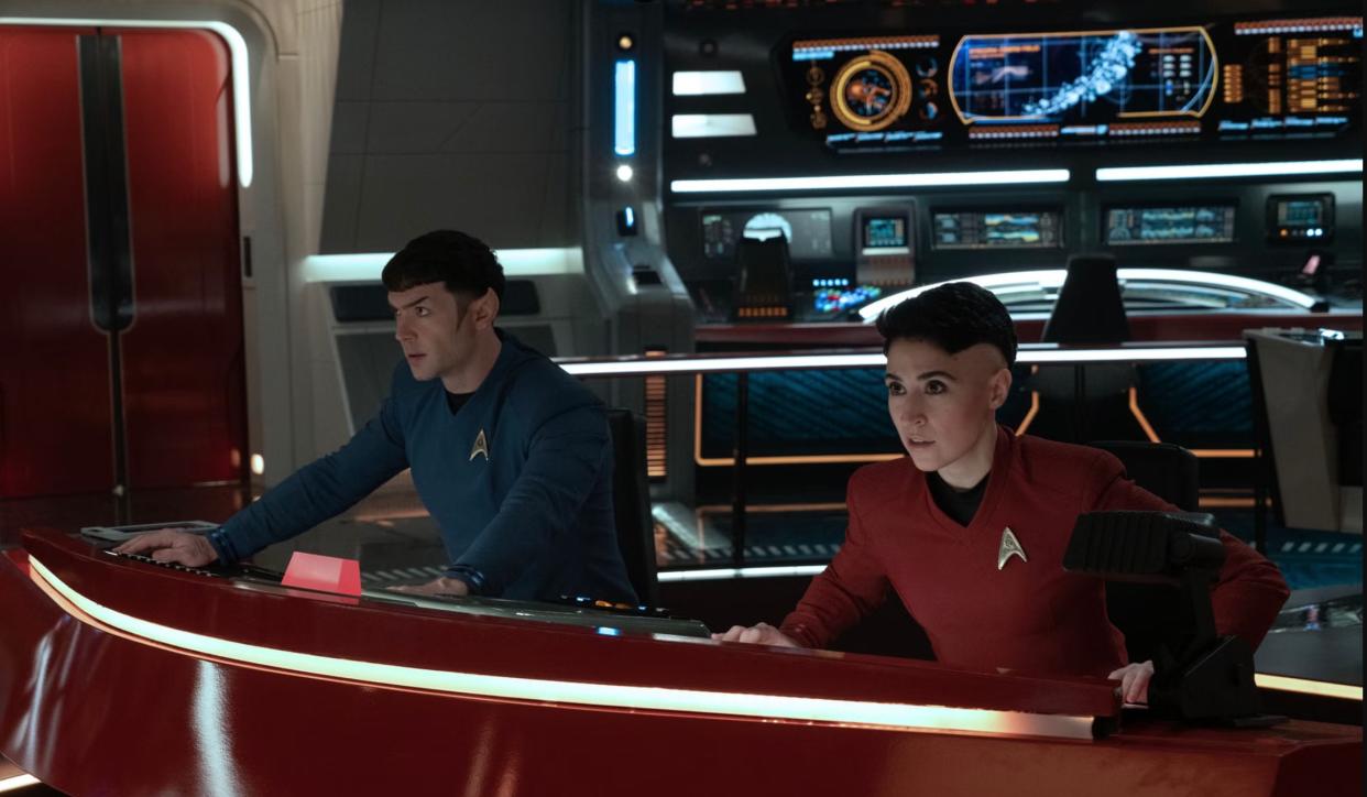  two star trek characters sit at a console aboard their ship 