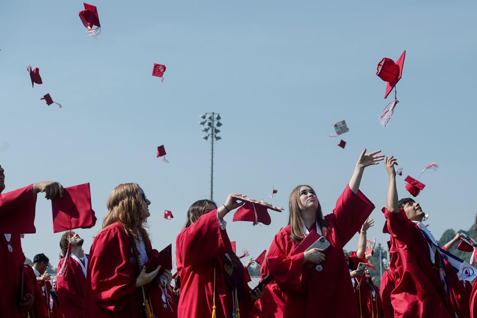 Erwin High graduates toss their caps into the air at the end of their commencement ceremony June 10, 2023.