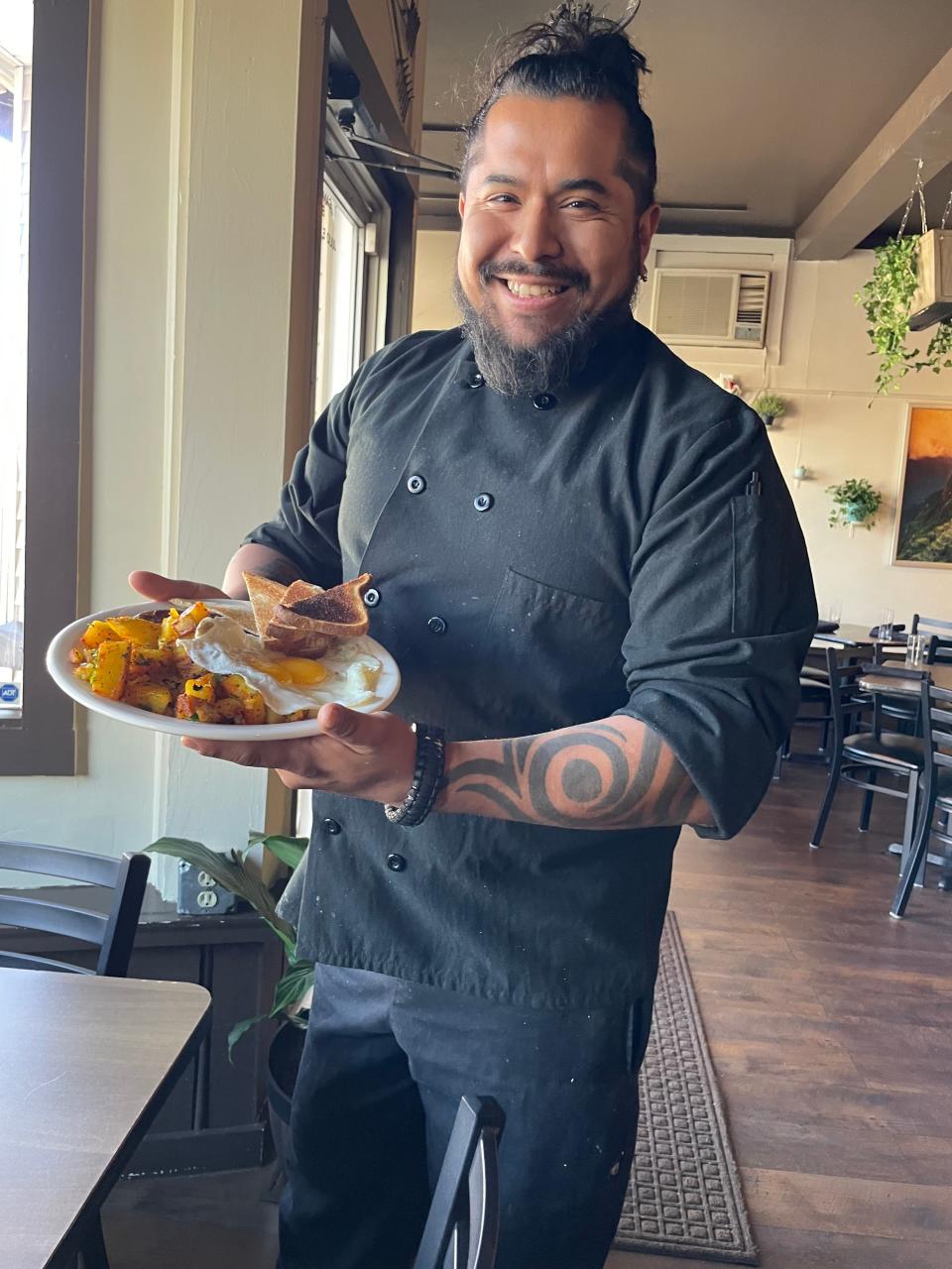 Canggio Restaurant Head Chef and Owner Julio Cancho holds a plate of home fries with egg, and toast, one of the  dishes to be offered during the Easter brunch.