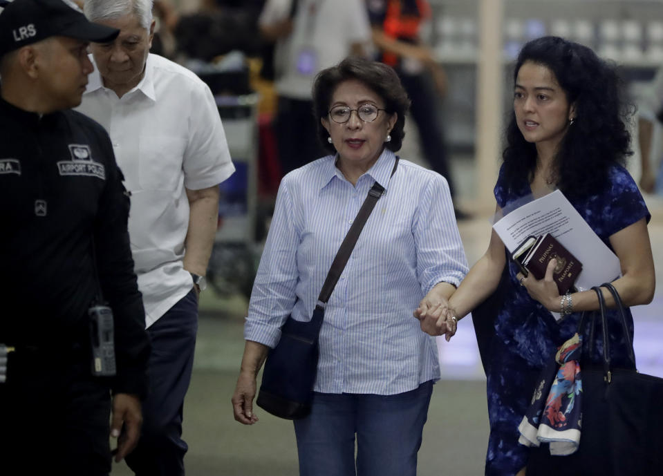 Former Philippine Supreme Court justice Conchita Carpio-Morales, center, is escorted out of the Ninoy Aquino International Airport upon arrival from Hong Kong where she was stopped by Immigration authorities and was held in a room at Hong Kong's airport and ordered to take a flight back to Manila, Tuesday, May 21, 2019 in suburban Pasay city south of Manila, Philippines. Carpio-Morales, along with former Foreign Affairs Secretary Albert Del Rosario, second from left, once accused Chinese President Xi Jinping of crimes against humanity before the International Criminal Court. (AP Photo/Bullit Marquez)