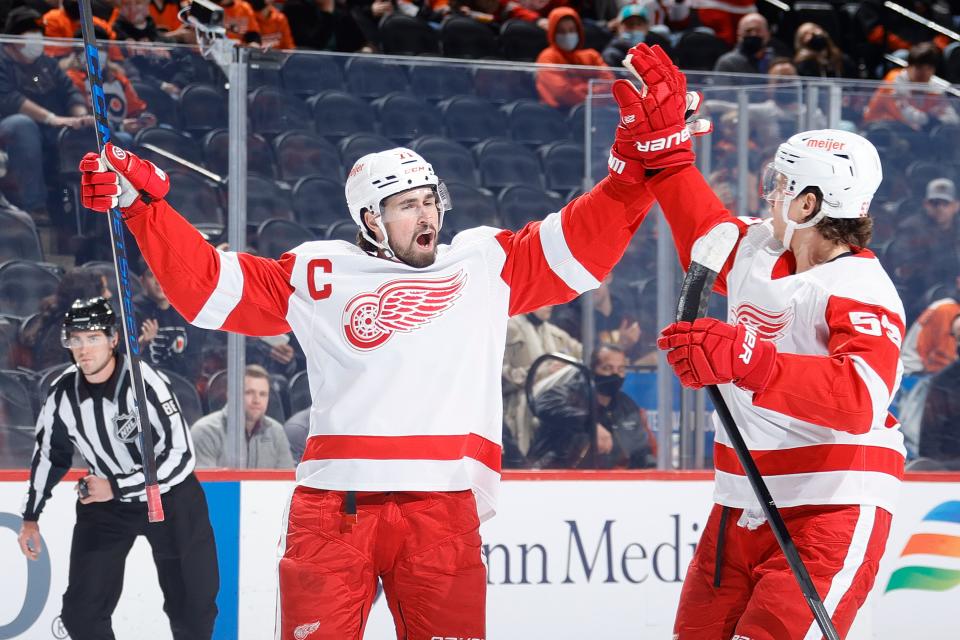Dylan Larkin, left, and Moritz Seider of the Detroit Red Wings celebrate a goal by Larkin during the first period against the Philadelphia Flyers on Feb. 9, 2022 at the Wells Fargo Center in Philadelphia.