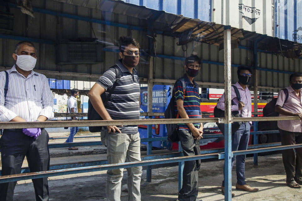 People wait outside a bus terminus in Kolkata, in the eastern Indian state of West Bengal, Wednesday, June 3, 2020. More states opened up and crowds of commuters trickled onto the roads in many of India's cities on Monday as a three-phase plan to lift the nationwide coronavirus lockdown began despite an upward trend in new infections. (AP Photo/Bikas Das)