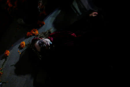 An activist with her face painted to look like the popular Mexican figure "Catrina" performs as she takes part in a march against femicide during the Day of the Dead in Mexico City, Mexico, November 1, 2017. REUTERS/Carlos Jasso