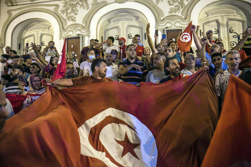 FILE - Tunisians celebrate the exit polls indicating a vote in favor of the new Constitution, in Tunis, late Monday, July 25, 2022. Despite an election debacle, Tunisia's increasingly authoritarian president appears determined to upend the country's political system, threatening to unravel the fragile democracy and collapse the economy in the North African nation that a decade ago stood out as a model of good governance and economic prosperity in the aftermath of the Arab Spring protests. (AP Photo/Riadh Dridi, File)