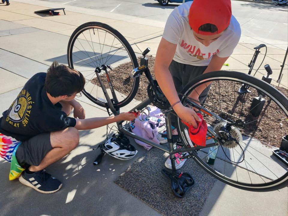 Volunteers with South Bend Bicycle Garage work on an attendee's bicycle during a 2022 First Fridays event in downtown South Bend. The Bike Valet service returns with the May 5, 2023, event.