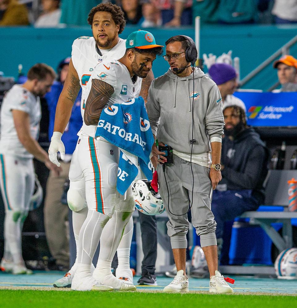 Quarterback Tua Tagovailoa talks with coach Mike McDaniel during a game against the Bills.