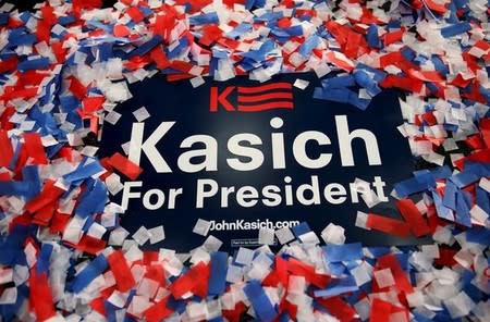 A John Kasich for president campaign sign is buried in confetti after the candidate delivered a victory speech after winning the Ohio Republican primary election at his election night rally in Berea, Ohio March 15, 2016. REUTERS/Aaron P. Bernstein