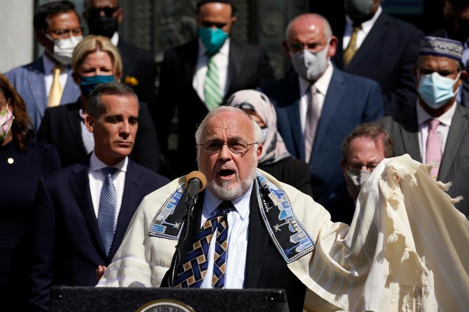 Rabbi Abraham Cooper, center, of the Simon Wiesenthal Center, speaks in front of civic and faith leaders outside City Hall, Thursday, May 20, 2021, in Los Angeles. Faith and community leaders in Los Angeles called for peace, tolerance and unity in the wake of violence in the city that is being investigated as potential hate crimes.