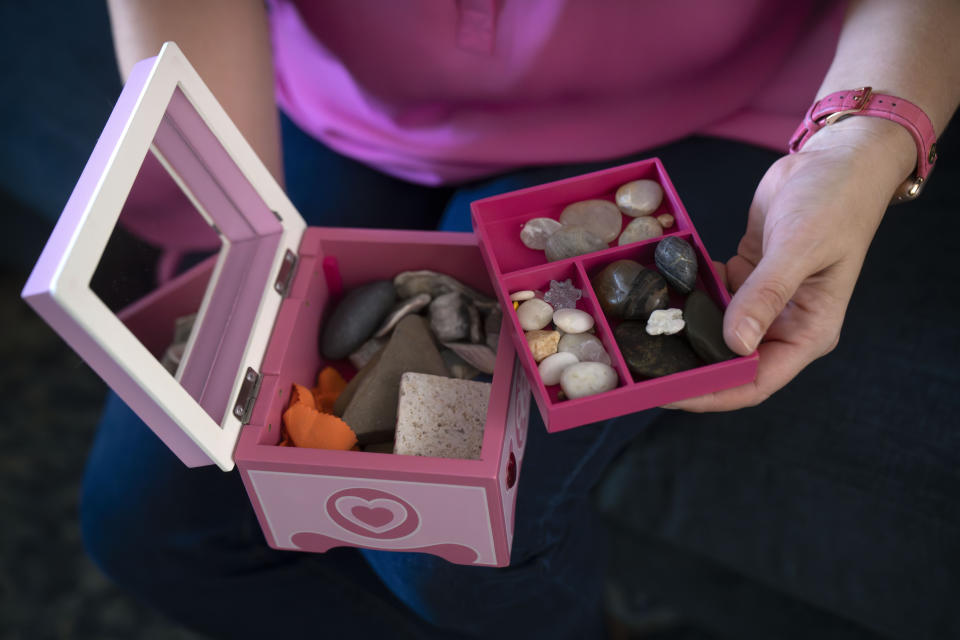 Jessica Riester Hart holds a jewelry box filled with rocks collected by her daughter, 5-year-old Allie Hart, who was struck and killed in 2021 by a driver while riding her bicycle in a crosswalk near their home, Thursday, Sept. 14, 2023, in Washington. (AP Photo/Mark Schiefelbein)