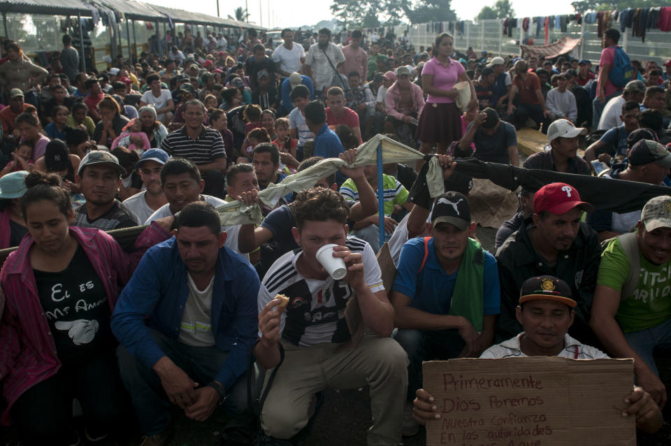 Honduras migrants wait to be attended by Mexican migration authorities on a bridge that stretches over the Suchiate River, connecting Guatemala and Mexico, in Tecun Uman, Guatemala, Sunday, Oct. 21, 2018. Despite Mexican efforts to stop them at the border, about 5,000 Central American migrants resumed their advance toward the U.S. border early Sunday in southern Mexico. (AP Photo/Oliver de Ros)