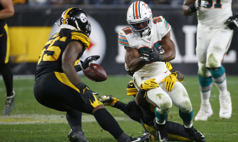 Mark Walton is stripped by Miami Dolphins DB Bobby McCain during a game.