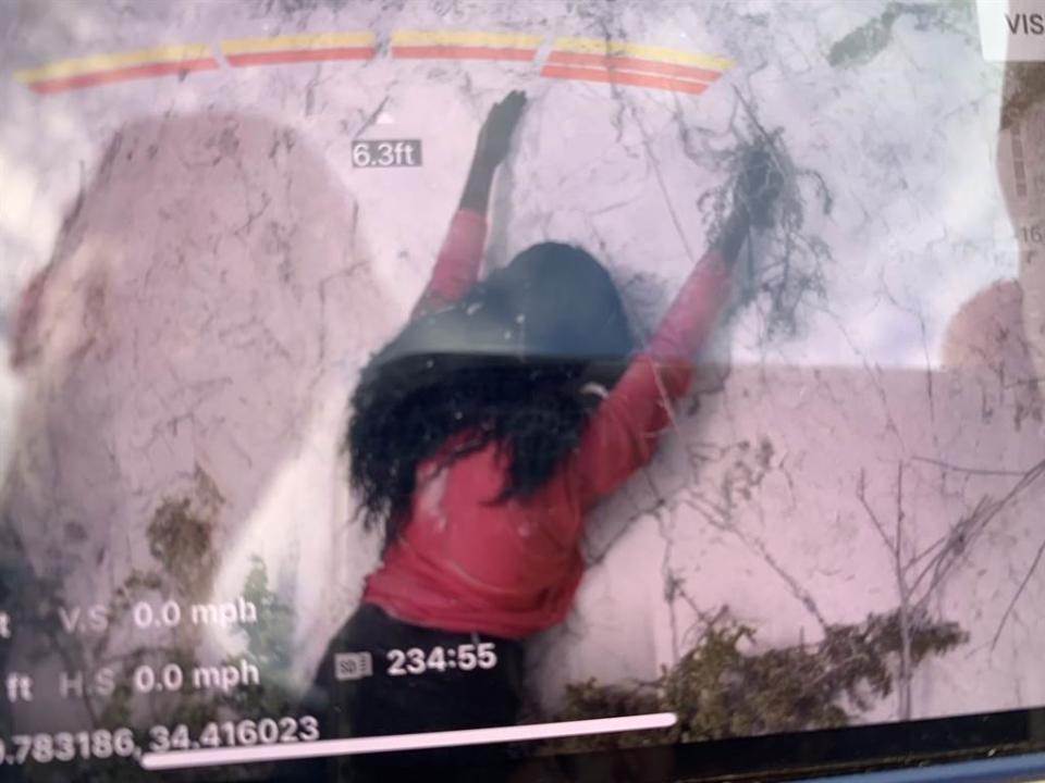 美國消防隊救援一名掛在峭壁上的女子，豈料靠近後才發現，它只是電影拍攝用的假人道具。(圖/翻攝自推特/@SBCFireInfo)