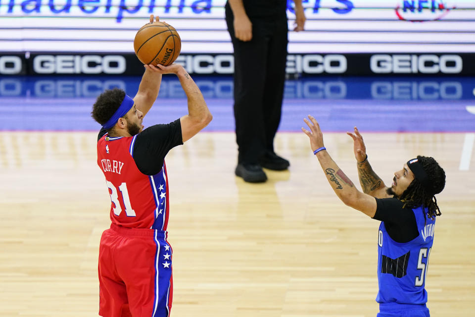 Seth Curry, de los 76ers de Filadelfia, dispara frente a Cole Anthony, del Magic de Orlando, en el encuentro del viernes 14 de mayo de 2021 (AP Foto/Matt Slocum)