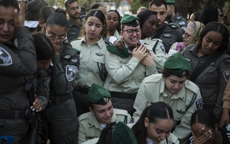 Border police officers mourn near the grave during a funeral for Sgt. Shai Garmai in Karmiel, Israel