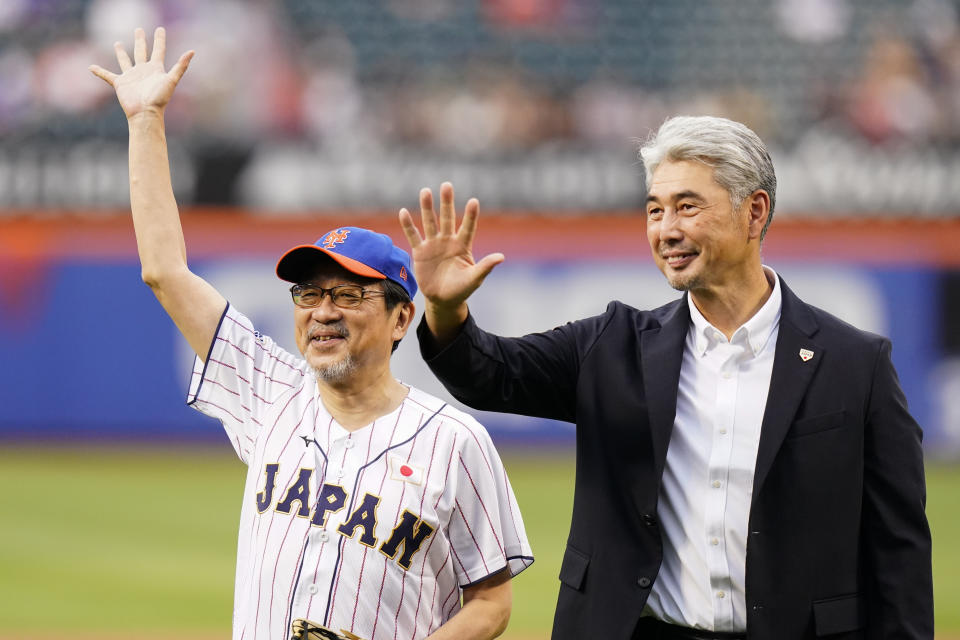 The Japanese consul-general in New York, Ambassador Mikio Mori, left, and former New York Mets pitcher Masato Yoshii waive to fans after a ceremonial first pitch before a baseball game between the Mets and the Colorado Rockies, Thursday, Aug. 25, 2022, in New York. (AP Photo/Frank Franklin II)