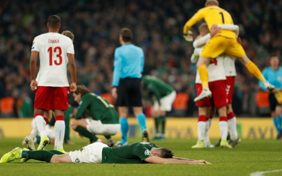 Ireland's players collapse to the turf as Denmark celebrate - Action Images via Reuters