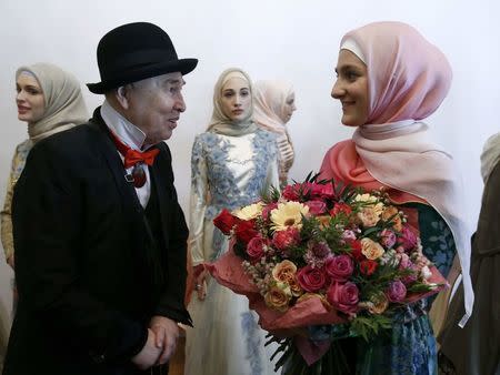 Designer Slava Zaitsev (L) speaks with Aishat Kadyrova, head of the Firdaws fashion house and daughter of the Chechen Republic leader Ramzan Kadyrov, at the Mercedes-Benz Fashion Week Russia in Moscow, Russia, March 17, 2017. REUTERS/Sergei Karpukhin