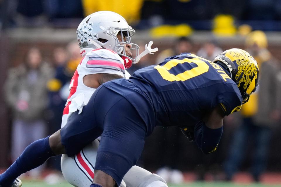 Michigan defensive back Mike Sainristil hits Ohio State running back TreVeyon Henderson.