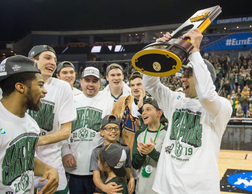 Northwest Missouri State Head Coach Ben McCollum holds the 2019 NCAA Division II Men's Basketball National Championship trophy above his head at Ford Center in Evansville, Ind., Saturday, March 30, 2019.  The Northwest Missouri State Bearcats defeated the Point Loma Sea Lions, 64-58.  