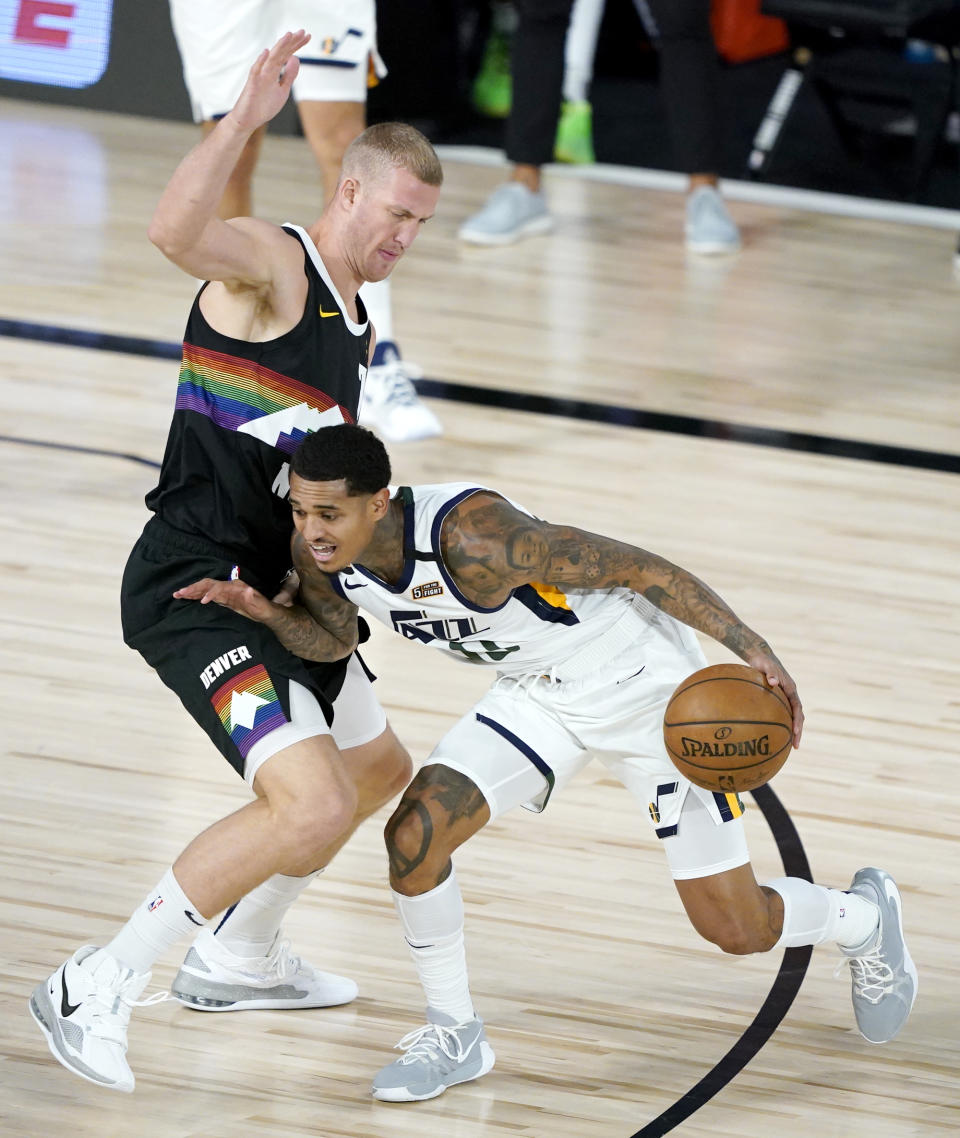 Utah Jazz's Jordan Clarkson (00) drives against Denver Nuggets' Mason Plumlee (7) during the first half of an NBA basketball first round playoff game, Monday, Aug. 17, 2020, in Lake Buena Vista, Fla. (AP Photo/Ashley Landis, Pool)
