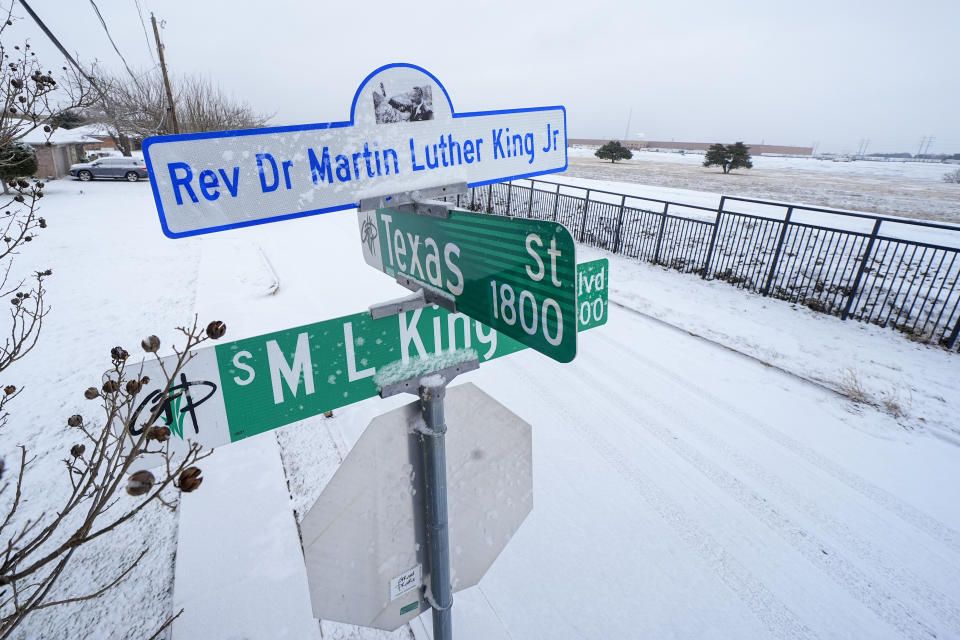 Snow is seen on signs at the intersection of Texas Street and Martin Luther King Jr. Boulevard during a winter storm, Monday, Jan. 15, 2024, in Grand Prairie, Texas. (AP Photo/Julio Cortez)