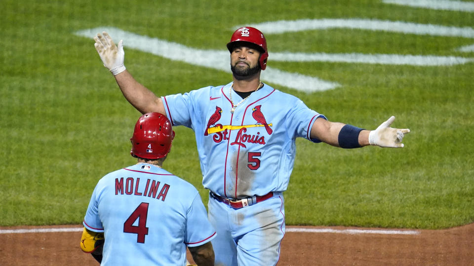 St. Louis Cardinals' Albert Pujols (5) is greeted by Yadier Molina (4) after hitting a two-run home run off Pittsburgh Pirates starting pitcher JT Brubaker during the sixth inning of a baseball game in Pittsburgh, Saturday, Sept. 10, 2022. (AP Photo/Gene J. Puskar)