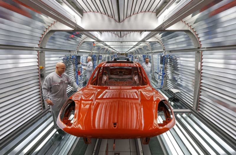 Porsche employees check the paintwork of the vehicles in the light tunnel at the Leipzig plant. Sports and off-road vehicle manufacturer Porsche publishes its business figures for the past year at the Porsche plant in Leipzig. Jan Woitas/dpa