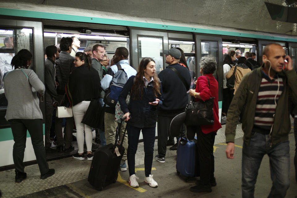 Commuters board a train, in Gare du Nord railway station, in Paris, Friday, Sept. 13, 2019. Paris metro warns over major strike, transport chaos Friday. (AP Photo/Thibault Camus)