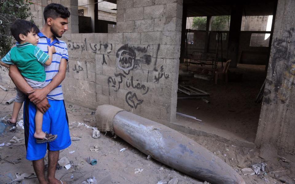 People inspect an Israeli missile that did not explode in Gaza City - SAMAR ABU ELOUF /NYTNS / Redux / eyevine 