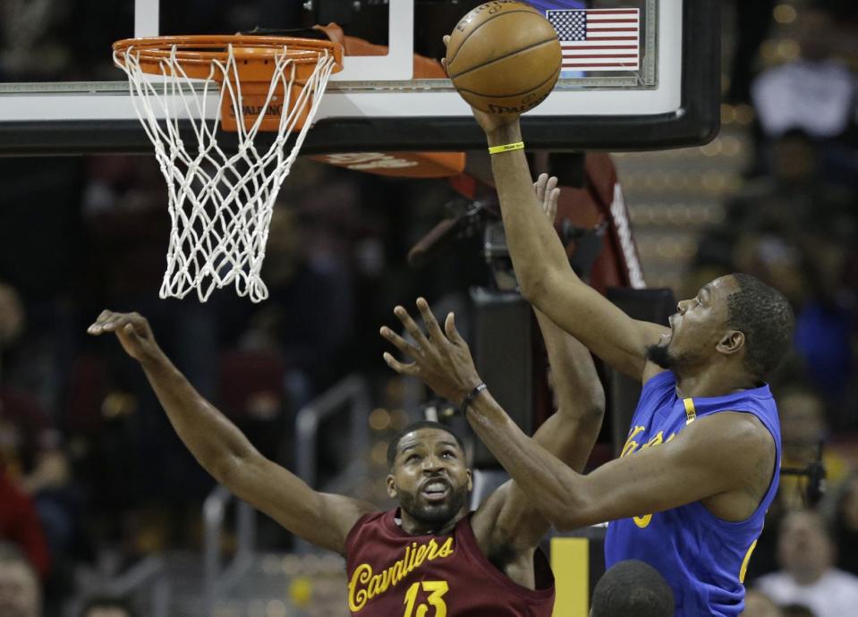 Golden State Warriors' Kevin Durant, right, drives to the basket against Cleveland Cavaliers' Tristan Thompson in the first half of an NBA basketball game, Sunday, Dec. 25, 2016, in Cleveland. (AP Photo/Tony Dejak)