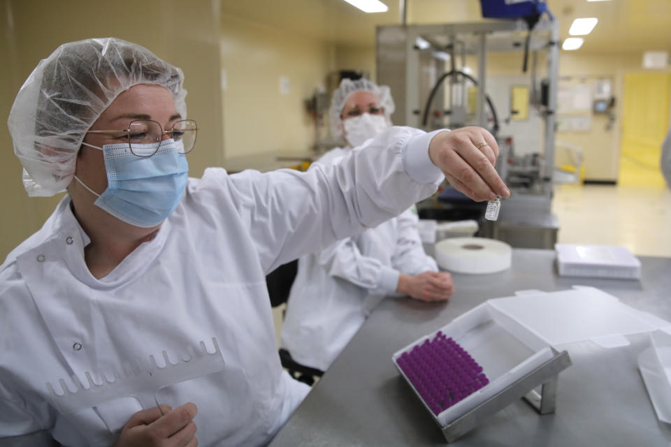 Employees work at the Delpharm plant in Saint-Remy-sur-Avre, west of Paris, Friday, April 9, 2021 in Paris. The Delpharm plant started bottling Pfizer vaccines this week as France tries to make its mark on global vaccine production, and speed up vaccinations of French people amid a new virus surge. (AP Photo/Christophe Ena, Pool)