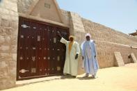 Workers pose in front of the newly restored doors of the 15th-century Sidi Yahia mosque hacked apart by jihadists in Mali's ancient city of Timbuktu four years ago