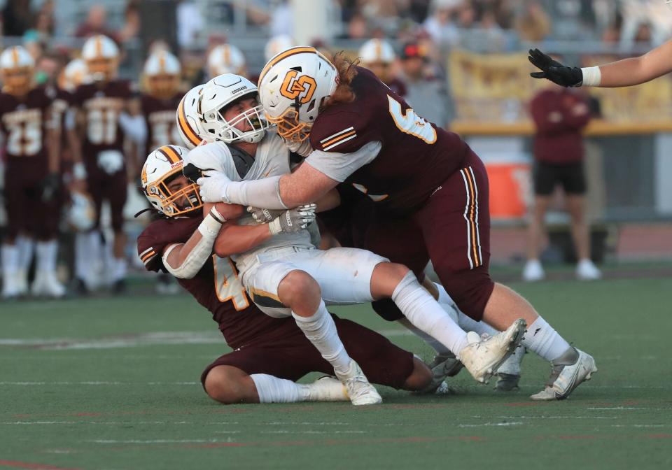 Ventura's Dylan Garcia is crunched by Simi Valley's Luke Perenchio, Andrew Rezinas and Sean Brown during the teams' season-opening game on Aug. 19.