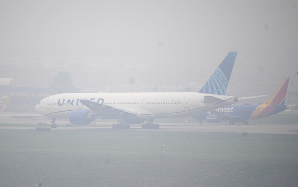 Jetliners taxi in heavy smoke at Denver International Airport Friday, May 19, 2023, in Denver. Smoke from numerous wildfires burning in the Canadian province of Alberta has rolled into Colorado, triggering air quality health advisory alerts across the state and giving Denver the ranking of third worst air quality of any major cities across the globe for the day. (AP Photo/David Zalubowski)