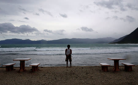 A resort worker looks out at a beach at an empty resort as Typhoon Haima strikes Pagudpud, Ilocos Norte in northern Philippines, October 20, 2016. REUTERS/Erik De Castro