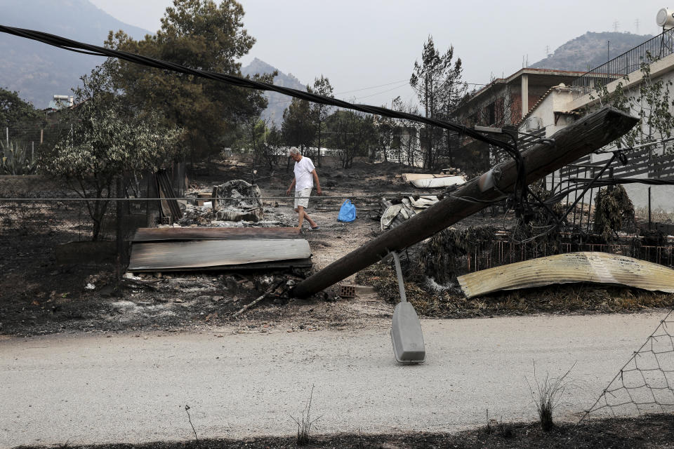 <p>A man collects belongings after a forest fire in Kineta village, west of Athens, Tuesday, July 24, 2018. (Photo: Yorgos Karahalis/AP) </p>